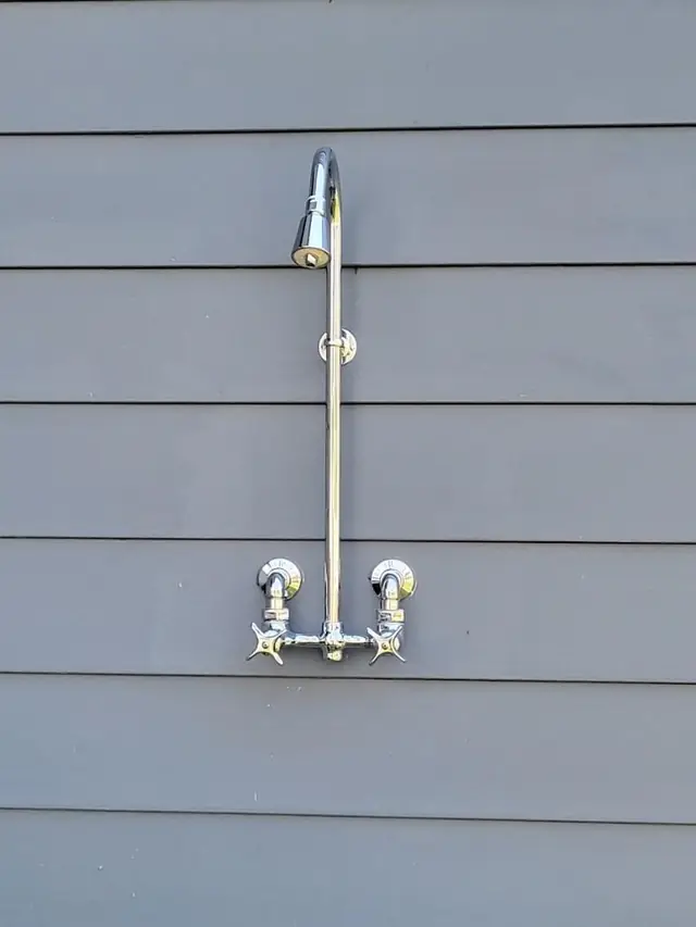 Exterior shower fixture installation against residential siding