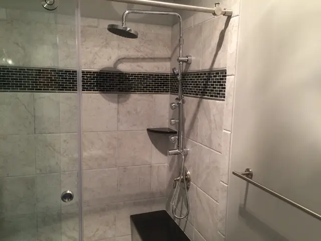 Finished tiled walk-in shower with rain head and handheld fixture installed by Chesapeake Plumbing